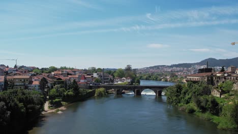 Atemberaubende-Luftaufnahme-Der-Berühmten-Mittelalterlichen-Brücke-In-Barcelos,-Portugal,-Mit-Blick-Auf-Die-üppige-Flusslandschaft-Und-Die-Stadt