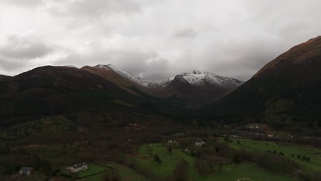 Aerial-revealing-shot-of-the-beinn-a-bheithir-munros-covered-in-snow-in-winter