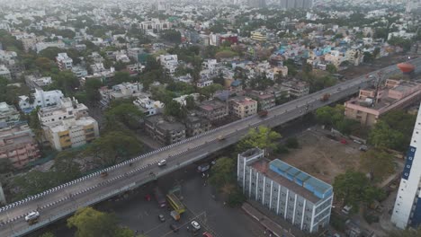 A-captivating-drone-shot-of-Chennai,-highlighting-the-city's-bustling-streets-and-towering-skyscrapers-against-a-backdrop-of-swirling-clouds