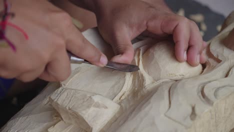 Hands-Of-Wood-Carver-Carving-Balinese-Barong-Mask-In-Bali,-Indonesia---Close-Up