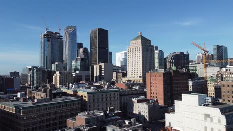 Vista-Aérea-De-La-Ciudad-De-Montreal-Con-Un-Moderno-Paisaje-Urbano-Inteligente-Durante-Un-Día-Soleado-Con-Cielo-Despejado,-Sitio-De-Grúas-De-Construcción-Para-El-Desarrollo-Urbano