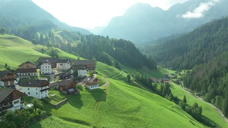 Cinematic-aerial-tilt-up-footage-of-the-picturesque-farm-houses-on-the-lush-green-hills-of-the-La-Val-village-in-the-Italian-Dolomites