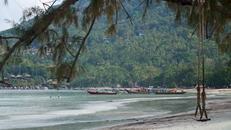 Filmischer-Blick-Auf-Einen-Thailändischen-Strand-Mit-Longtail-Booten-In-Der-Ferne