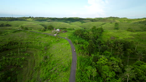 Driving-down-steep-slope,-scooter-transportation,-Bali-landmark,-aerial