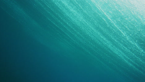 Unterwasseransicht-Der-Meeresoberfläche,-Während-Ranken-Sich-Von-Einer-Welle-über-Das-Wasser-Ausdehnen