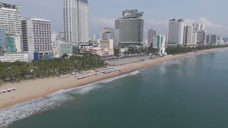 Un-Panorama-Aéreo-Inmersivo-Que-Revela-El-Encanto-Del-Horizonte-De-Nha-Trang,-Con-Tenues-Nubes-Que-Añaden-Un-Toque-De-Dramatismo-Al-Paisaje-Urbano-Mientras-El-Tráfico-Fluye-Con-Gracia-Debajo.