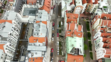 Vista-Aérea-De-Arriba-Hacia-Abajo-De-Un-Diseño-Urbano-Denso,-Donde-Los-Variados-Colores-De-Los-Tejados-De-Los-Edificios-De-La-Ciudad-Proporcionan-Un-Mosaico-Vibrante