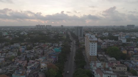 Eine-Atemberaubende-Luftaufnahme-Von-Chennai,-Die-Das-Pulsierende-Stadtleben-Vor-Einer-Kulisse-Aus-Dahinziehenden-Wolken-Und-Majestätischen-Wolkenkratzern-Zeigt