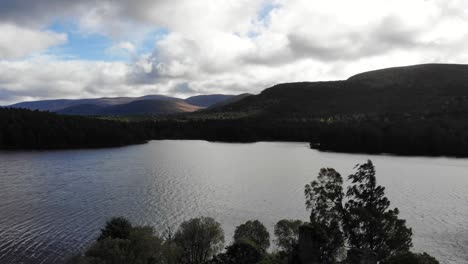 Aerial-View-Of-Ruins-Of-Loch-an-Eilein-Castle-In-Lake-Surrounded-By-Scottish-Highland-Landscape