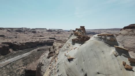 Soaring-over-Utah's-majestic-landscape,-the-barren-expanse-and-canyon-cliffs-unfold-beneath,-showcasing-the-rugged-terrain-and-awe-inspiring-beauty-of-the-American-West