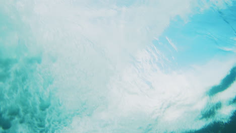 Underwater-rearview-of-ocean-wave-building-and-crashing-with-whitewash