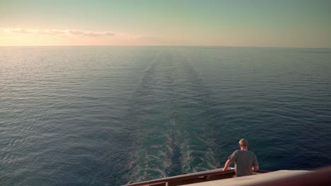 Mann,-Der-Auf-Dem-Segelkreuzfahrtschiff-Bei-Sonnenuntergang-Am-Abend-Auf-Das-Meer-Blickt
