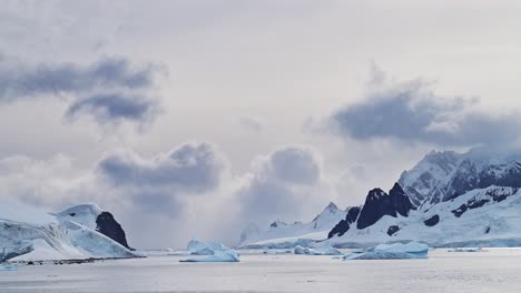 Sunset-Antarctica-Mountains-Scenery,-Beautiful-Landscape-and-Dramatic-Clouds-and-Sky-with-Mountain-Peaks-and-Icebergs,-Global-Warming-and-Climate-Change-in-Antarctic-Peninsula-with-Ocean-Sea-Water