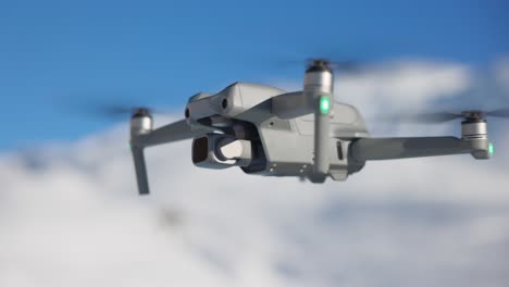 Modern-DJI-Air-compact-drone-flying-with-snowy-mountains-in-background