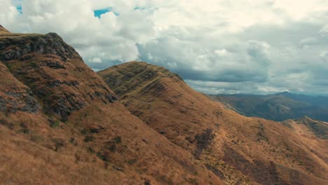 The-golden-mountain-tops-of-South-east-Peruvian-Andes-near-Cuzco-during-dry-season,-dolly-in-aerial