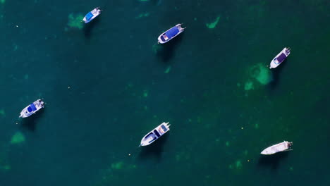 Top-down,-close-up-drone-shot-of-boats-moored-in-the-ocean