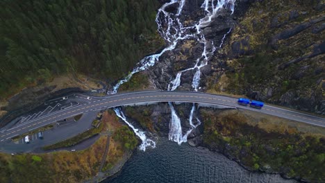 Various-vehicles-across-the-bridge-in-front-of-Langfossen-Waterfall,-Norway