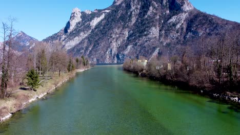 Calm-river-Traun-flowing-through-Ebensee-in-Upper-Austria,-with-Traunstein-mountain-backdrop,-sunny-day