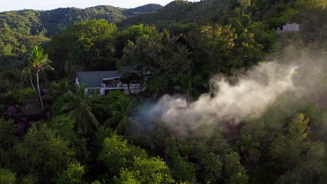 Drone-shot-captures-big-plumes-of-smoke-coming-from-a-property-on-top-of-a-mountain