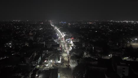 aerial-drone-shot-moving-towards-brightly-lit-apartments-skyscrapers-with-lights-and-parks-showing-the-architecture-of-real-estate-and-property