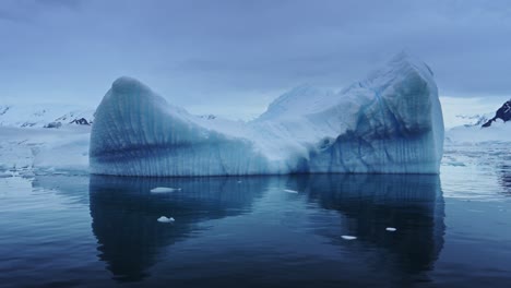 Aerial-drone-shot-of-Antarctica-Icebergs,-Reflections-Reflecting-in-Calm-Still-Sea-Water-of-Big-Beautiful-Massive-Large-Icebergs-Floating-in-the-Ocean-in-the-Beautiful-Southern-Sea