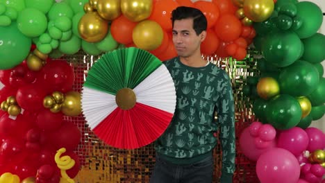 Mexikanischer-Mann-Dreht-Traditionelle-Rosette-Vor-Goldenem-Hintergrund,-Dekoriert-Mit-Luftballons