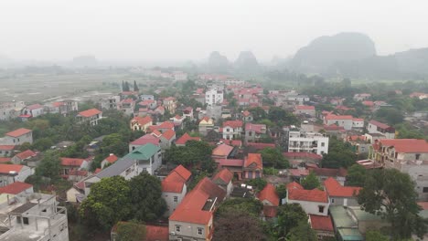 Luftaufnahme-Einer-Drohne,-Die-Durch-Die-Stadt-Ninh-Binh-Mit-Häusern-Zieht