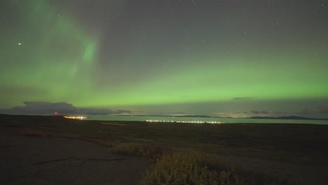 The-dark-sky-above-the-fjord-and-the-small-town-is-adorned-with-a-spectacular-exhibition-of-the-northern-lights