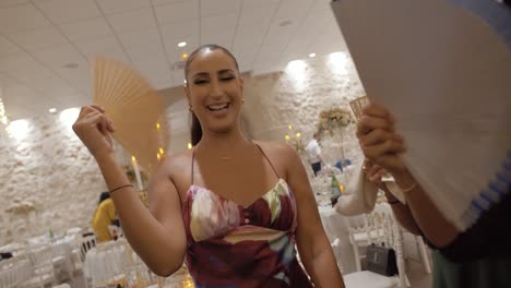 Slow-motion-shot-of-bridesmaids-dancing-on-the-dancefloor-at-a-wedding-with-fans