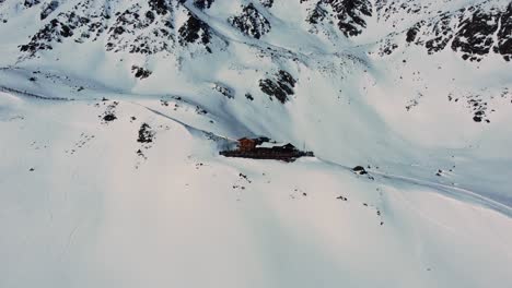 Restaurantgebäude-Auf-Schneebedecktem-Grat-In-Den-Alpen,-Hütte-In-Den-Alpen,-Luftaufnahme