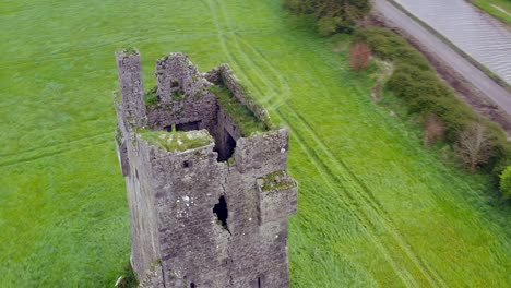 Castillo-De-Srah-Desde-Un-ángulo-Alto-Con-Mechones-De-Hierba-Cubiertos-De-Maleza,-órbita-Aérea