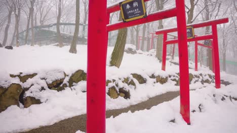 Red-Torii-Gates-in-the-Snow-at-Kitsune-Mura,-Fox-Village-in-Miyagi-Japan