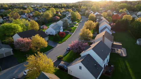 Dramatic-light,-aerial-turn-reveals-American-neighborhood,-residential-development-community-during-spring-season-magic-hour,-Small-Town-America