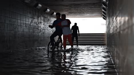 Residents-crossing-a-waterlogged-pedestrian-underpass-after-the-rain-hit-the-UAE-on-May-02,-2024