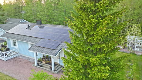 PV-cells-covering-a-detached-house-roof,-warm,-summer-morning---Aerial-view