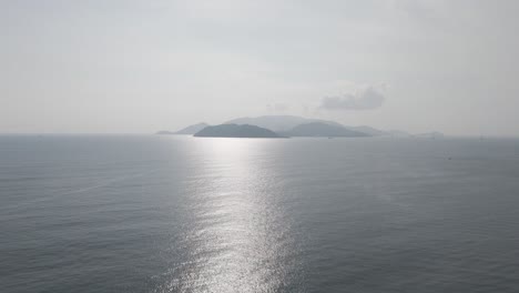 Una-Cautivadora-Perspectiva-Aérea-De-La-Isla-De-Nha-Trang,-Que-Muestra-Su-Icónico-Horizonte-Con-Nubes-Dinámicas