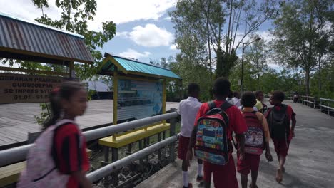 Los-Niños-Indonesios-Caminando-Fuera-De-La-Escuela-Camino-Pavimentado-Rural-Papua-Indonesia