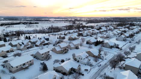 American-neighborhood-covered-in-snow-under-bright-orange-sunset-in-winter-evening