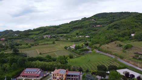 Vista-Aérea-Panorámica-Del-Pueblo-Con-Campos-De-Viñedos-Agrícolas-Y-Paisaje-De-Colinas-En-Euganei-Italia