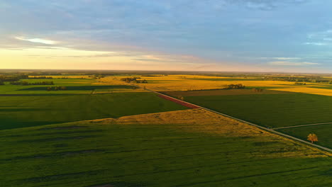 Goldener-Sonnenaufgang-über-Ruhiger-Ländlicher-Landschaft-Mit-Langer-Straße,-Luftaufnahme