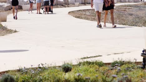 People-walk-along-the-promenade-by-the-sea-in-Paphos,-Cyprus