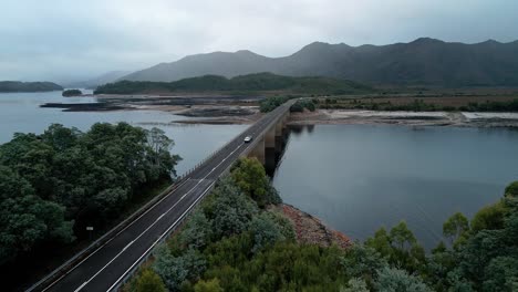 Drone-view-of-a-bridge-joining-city-over-Lake-Burbury-in-Tasmania,-Australia