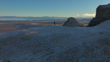 Annäherung-An-Bergwanderer-Zu-Fuß-Bis-Zum-Morgengrauen-Beleuchtet-Frostigen-Felsrand-Mit-Weitblick-Zum-Bergigen-Winterhorizont