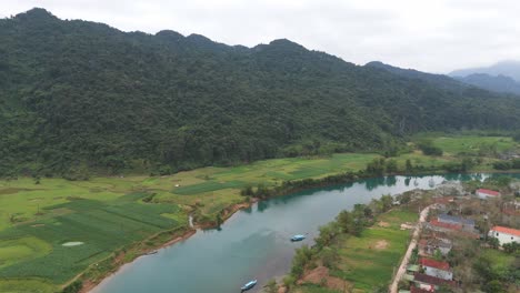 Aerial-footage-of-river-and-green-forest-with-mountain-natural-landscape
