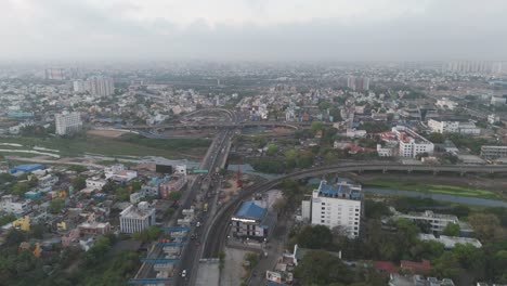 Eine-Faszinierende-Drohnenansicht-Der-Skyline-Von-Chennai-In-Der-Abenddämmerung,-Wobei-Die-Lichter-Der-Stadt-Den-Bewölkten-Abendhimmel-Erhellen