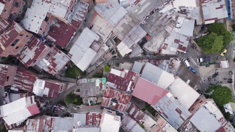 Aerial-top-view:-A-dense-fabric-of-homes-in-Medellin's-Comuna-13-favela,-Colombia