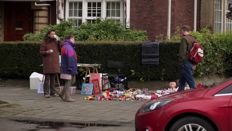 Woman-selling-second-hand-items-in-front-of-house-during-Koningsdag-celebration