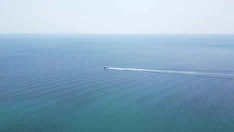 Drone-Siguiendo-Un-Barco-Navegando-Rápido-Sobre-Mar-Abierto