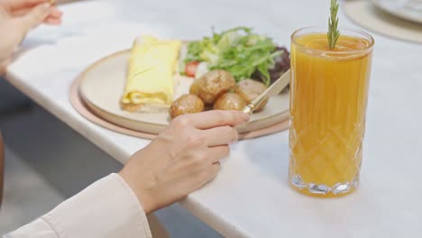 A-woman-eating-her-delicious-breakfast-in-fancy-restaurant-close-up-shot,-high-angle-shot,-insert-shot