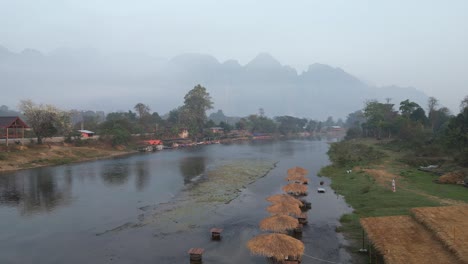 Drohnenaufnahme-Eines-Fluges-über-Den-Fluss-In-Richtung-Der-Berge-In-Vang-Vieng,-Der-Abenteuerhauptstadt-Von-Laos